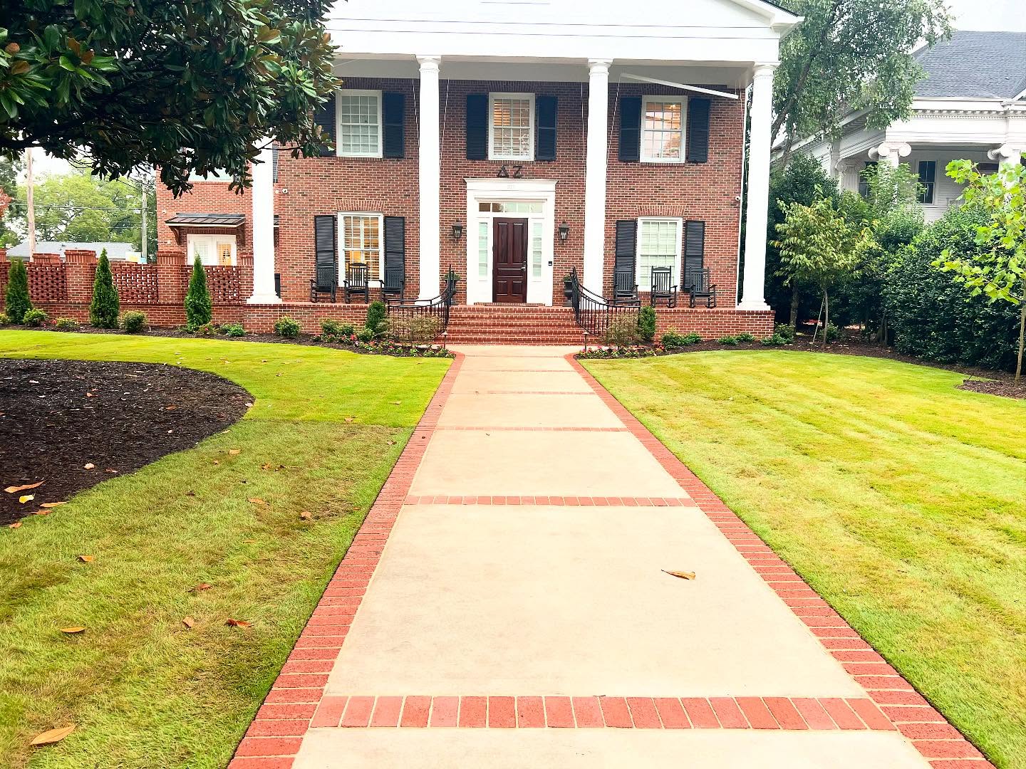 Professional commercial landscape with manicured lawn and brick walkway